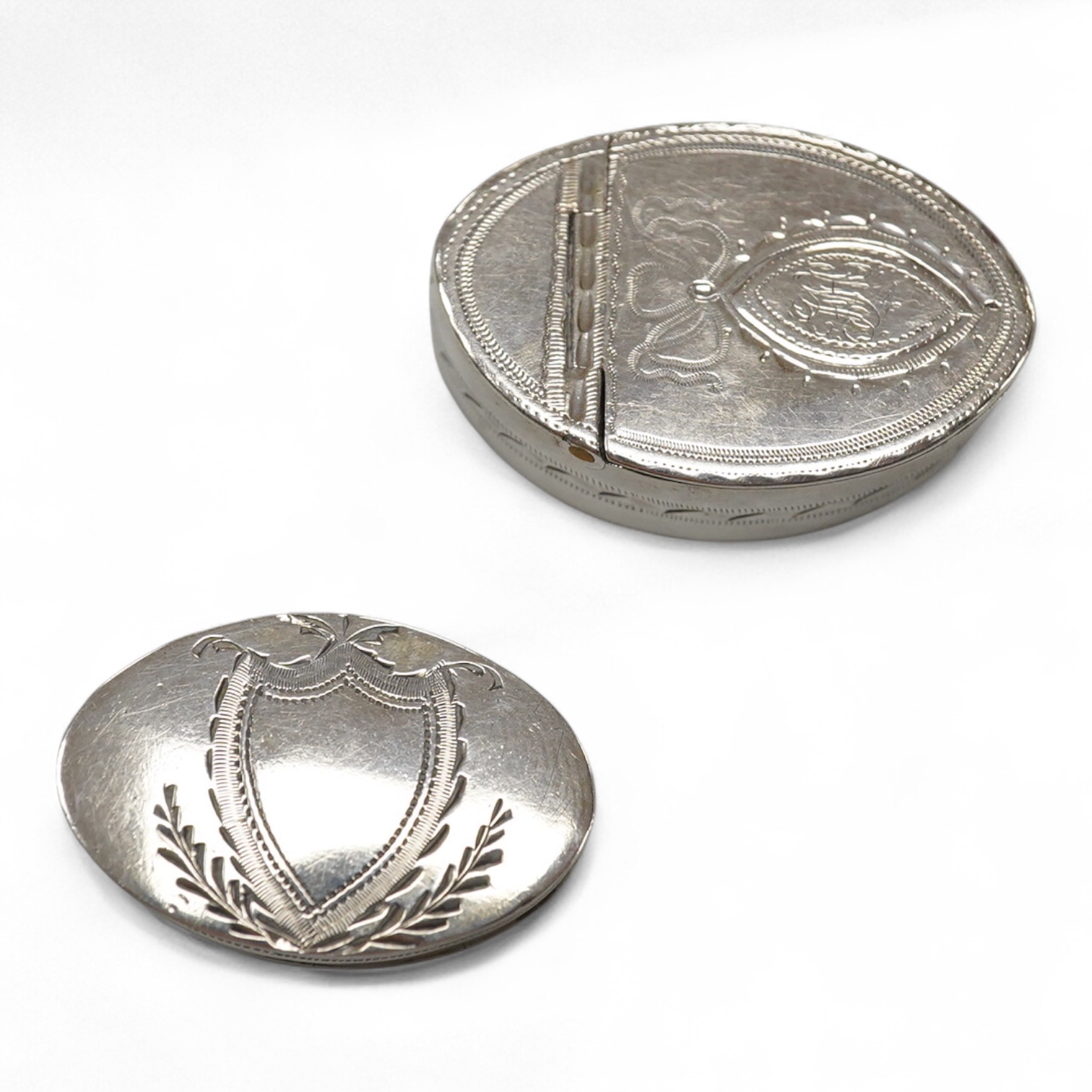 Two George III engraved silver oval patch boxes, largest with hinged cover, Samuel Pemberton, Birmingham, 1818, 28mm, the smaller by John Thornton, Birmingham, 1800.